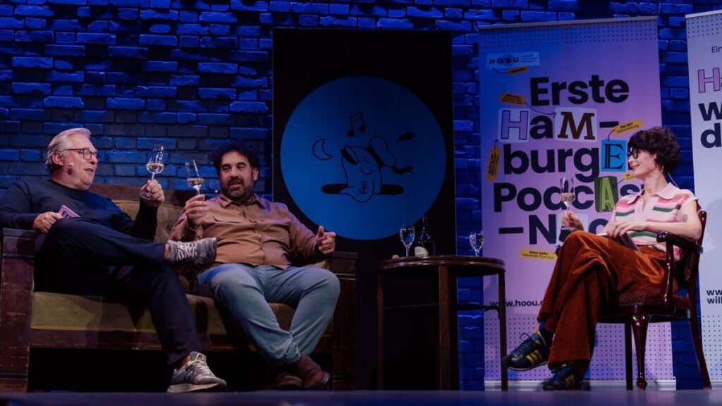 Zu sehen sind Regine Marxen und Boris Rogosch im Gespräch mit Onur Elci.