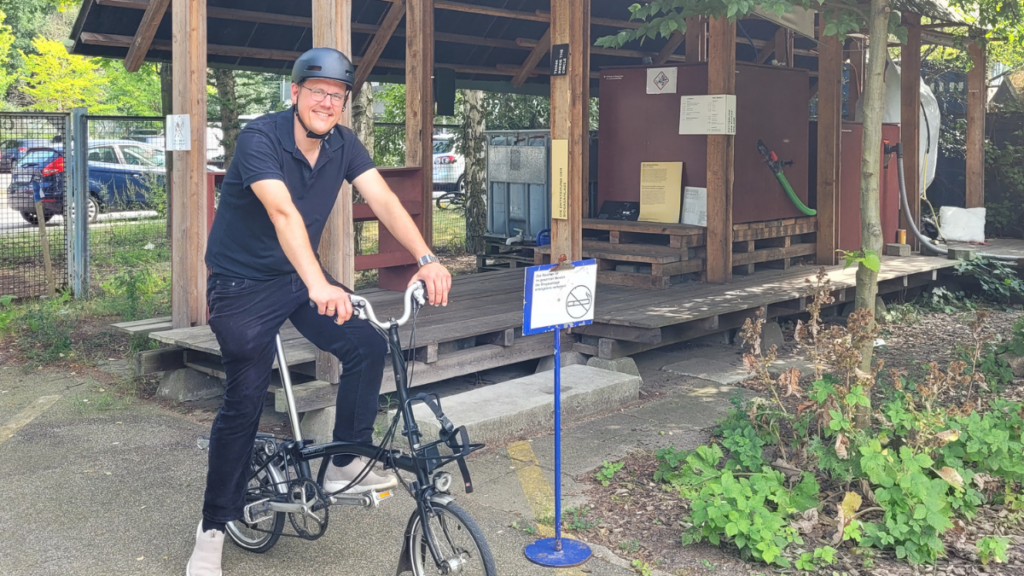 Das Bild zeigt Axel Dürkop auf dem Rad vor der Biogasanlage.
