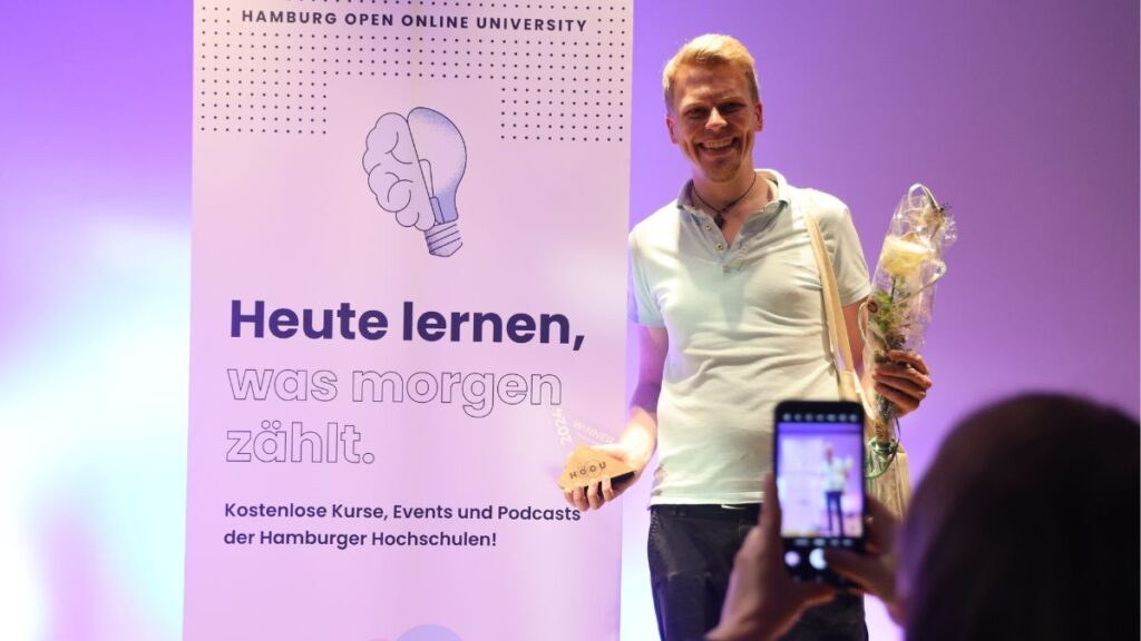 Philip Rose als Gewinner des Science and Art Slam 2024 auf der Bühne nach der Preisverleihung.