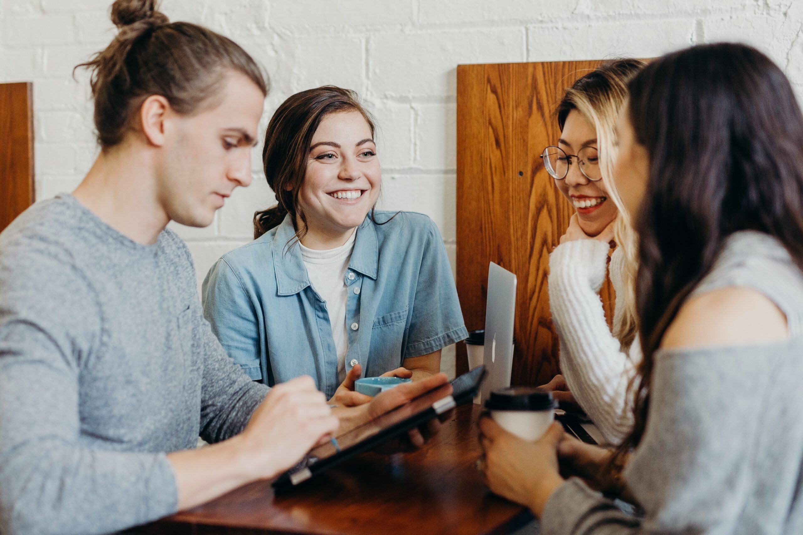 Vier Menschen stehen mit Notebook und Tablet beisammen