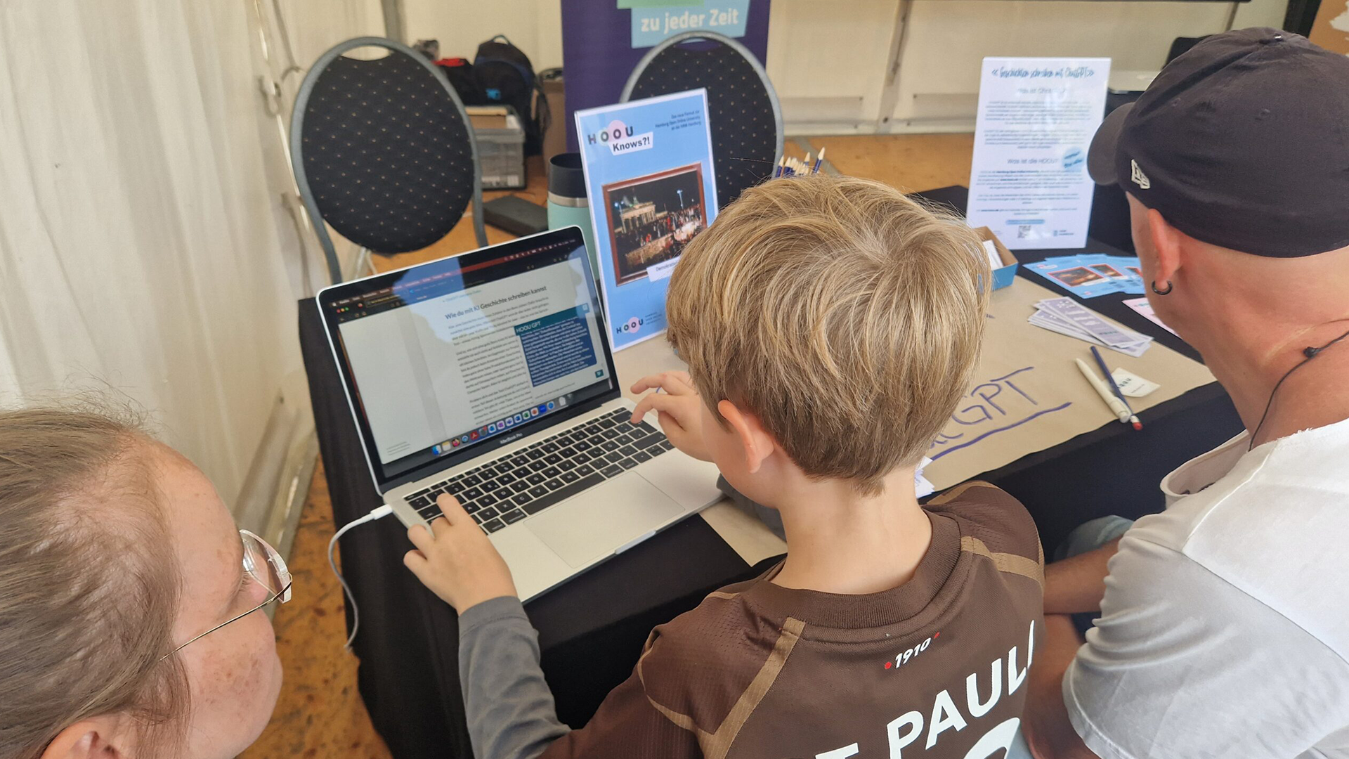 Ein junge sitzt an einem Notebook und probiert ChatGPT aus