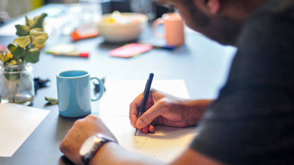 Eine Person schreibt mit einem Stift auf Papier