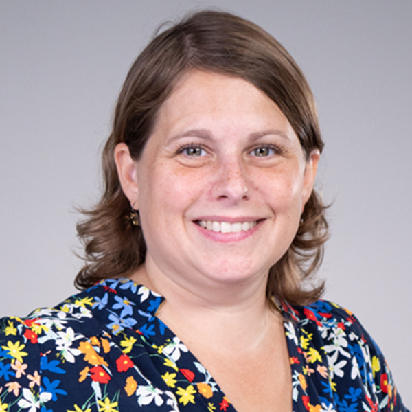 Porträt von Katrin Schröder vor einem grauen Studiohintergrund.