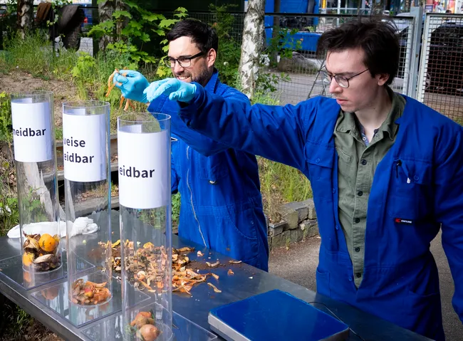 Aus Lebensmittelabfällen werden Biogas und Flüssigdünger. Steffen Walk (links) und René Hansen (rechts) sortieren den Abfall, bevor er geschreddert wird und in die Anlage kommt.